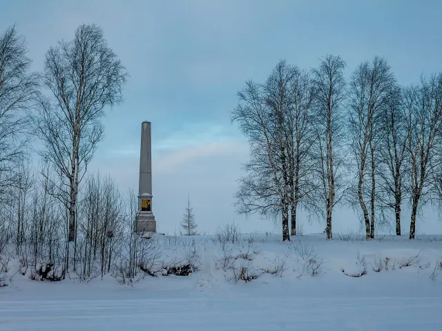 Обелиск 1846 года на дамбе канала, за ним — Белое озеро